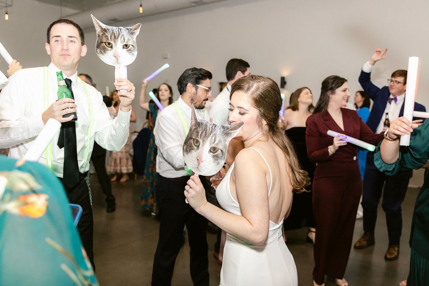 Wedding guests dance and celebrate together on a dance floor at a reception party.
