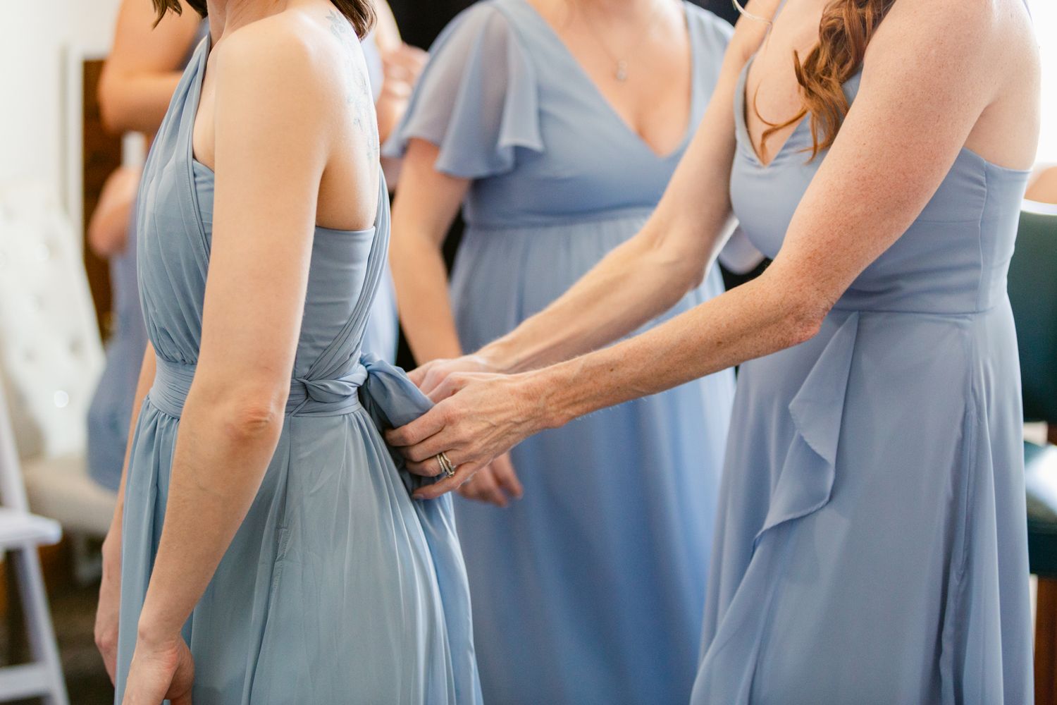 Bridesmaids in light blue dresses stand together during a wedding celebration.