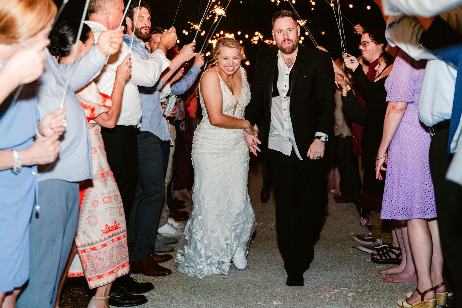 Wedding guests dance and celebrate on a crowded dance floor at an evening reception party.