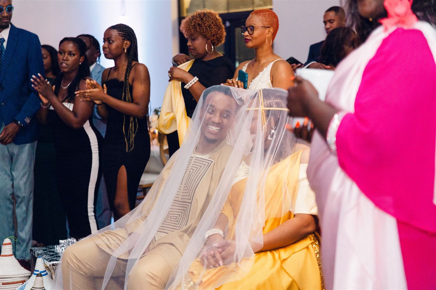 Wedding guests in traditional African attire dance and celebrate at a vibrant reception party.