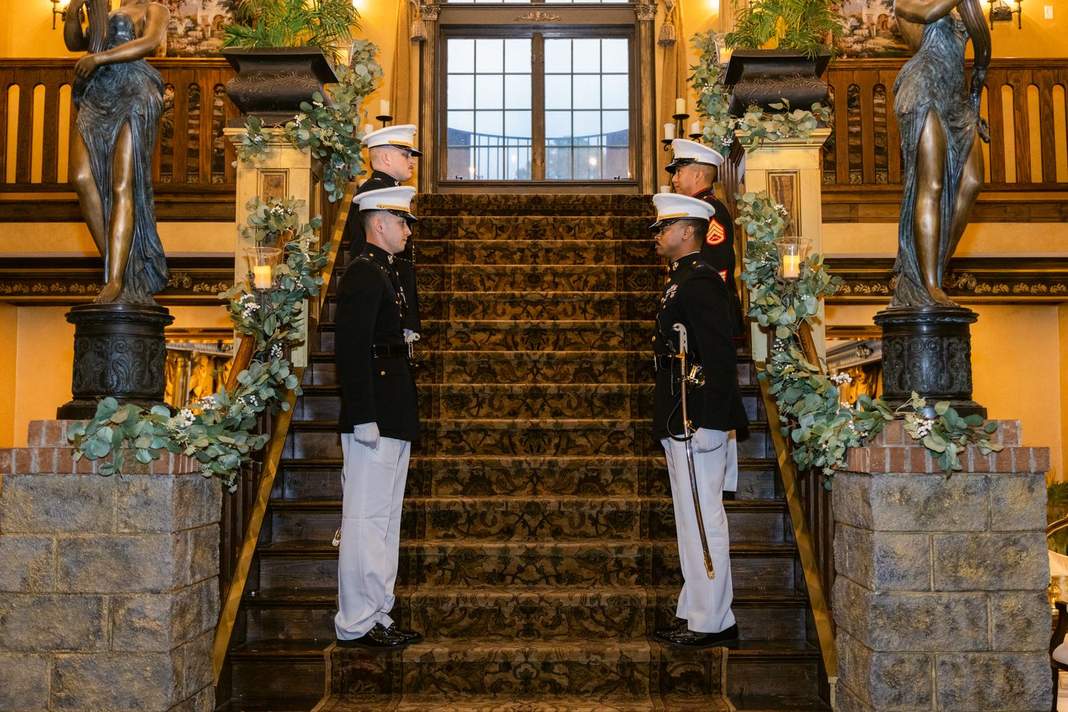 Elegant stone staircase decorated with white stockings and greenery for Christmas in a rustic brick building.