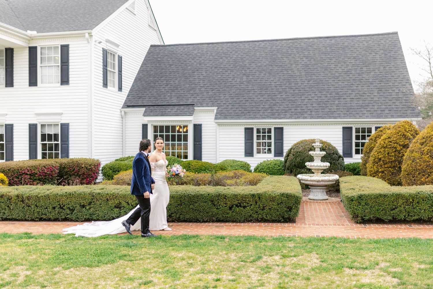 A series of five connected exterior photos showing a white colonial style house with black shutters and manicured landscaping.