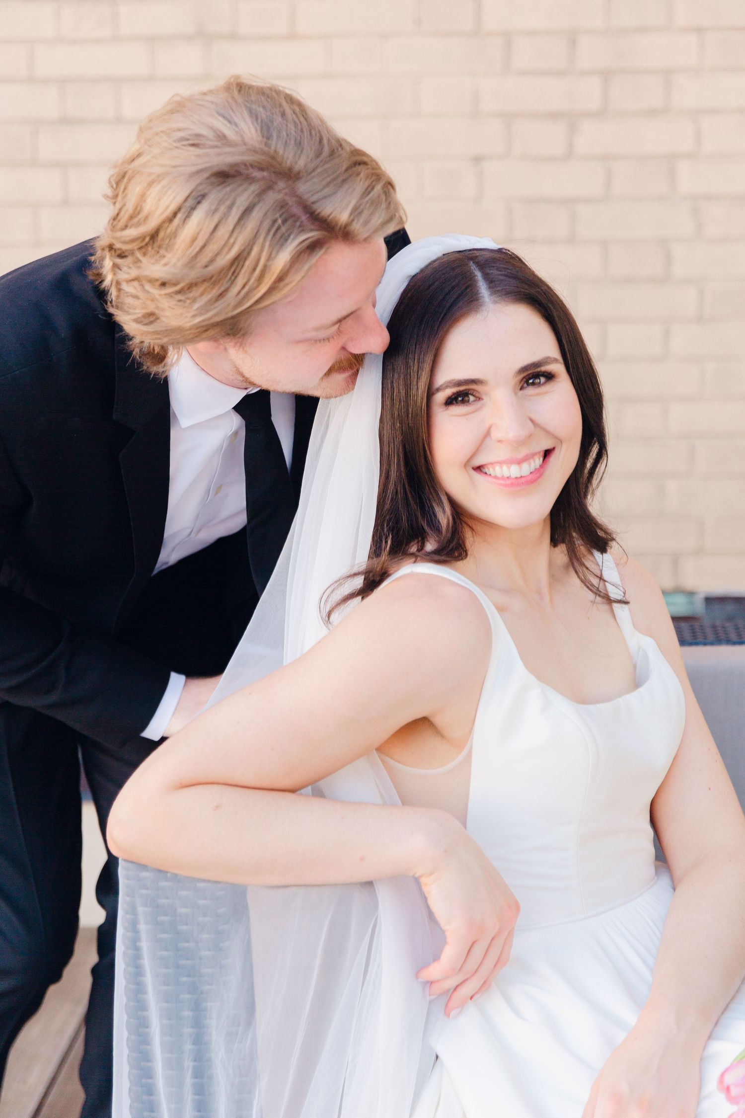 A candid wedding portrait showing a tender moment between newlyweds.