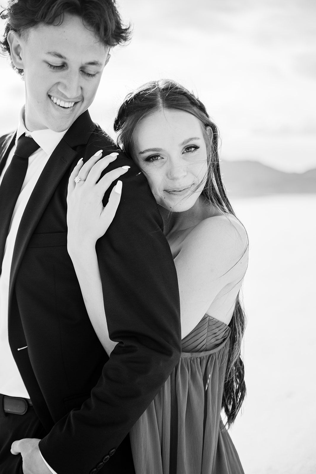 A romantic black and white photo series showing a couple embracing and smiling together in formal attire.