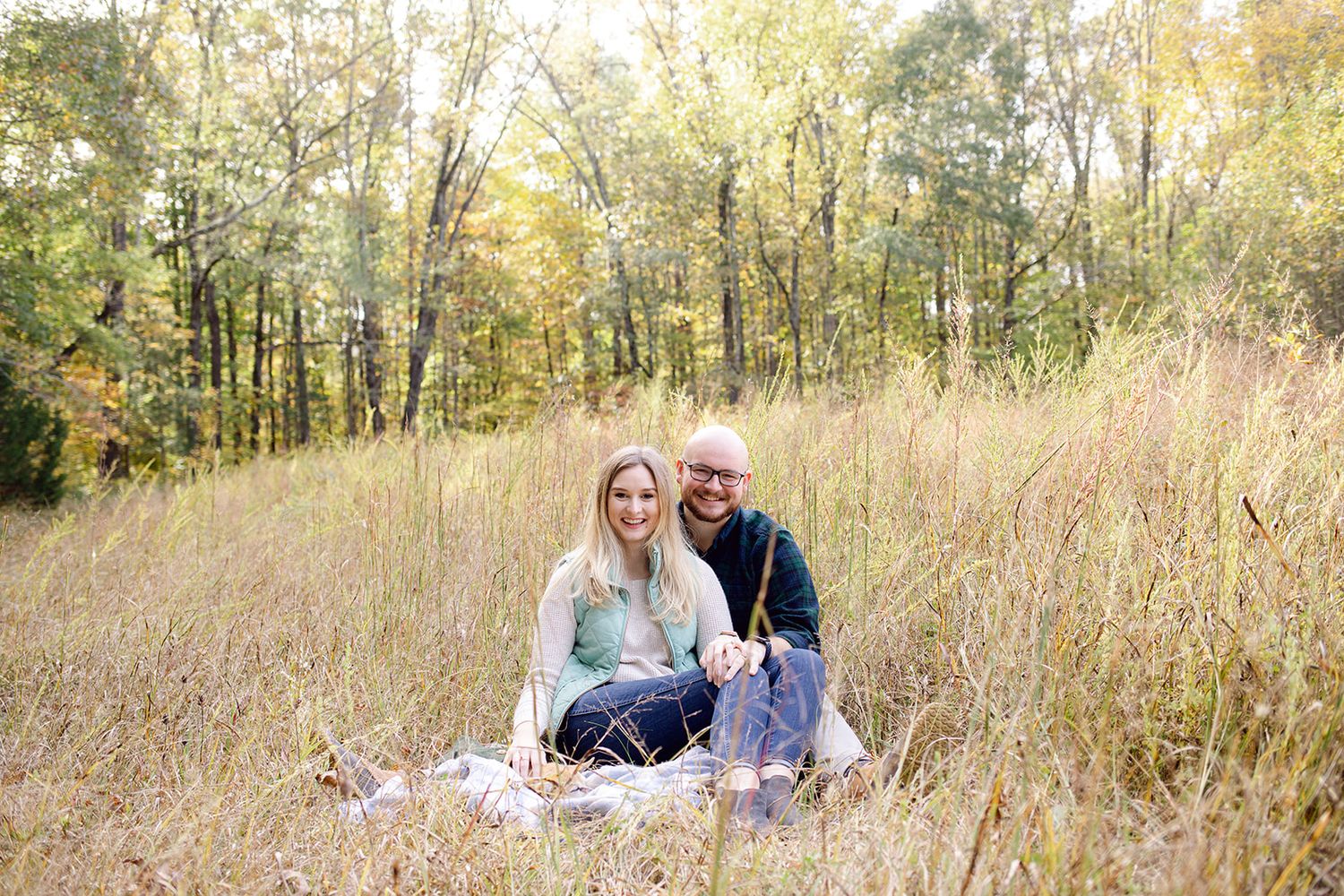 Romantic couple enjoying a picnic in a sunlit autumn field.