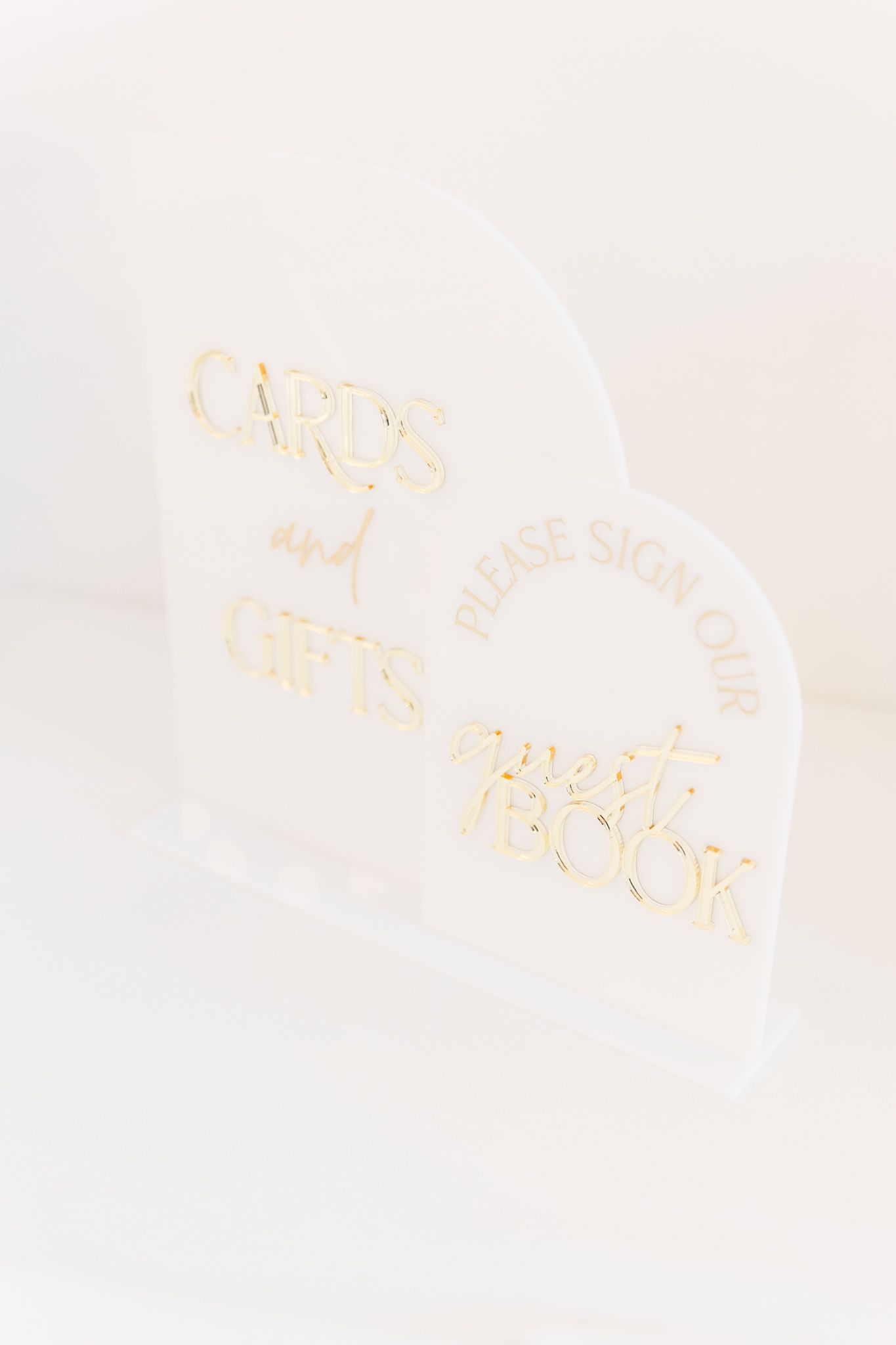 Minimalist white paper with elegant gold lettering in a blurred artistic composition.