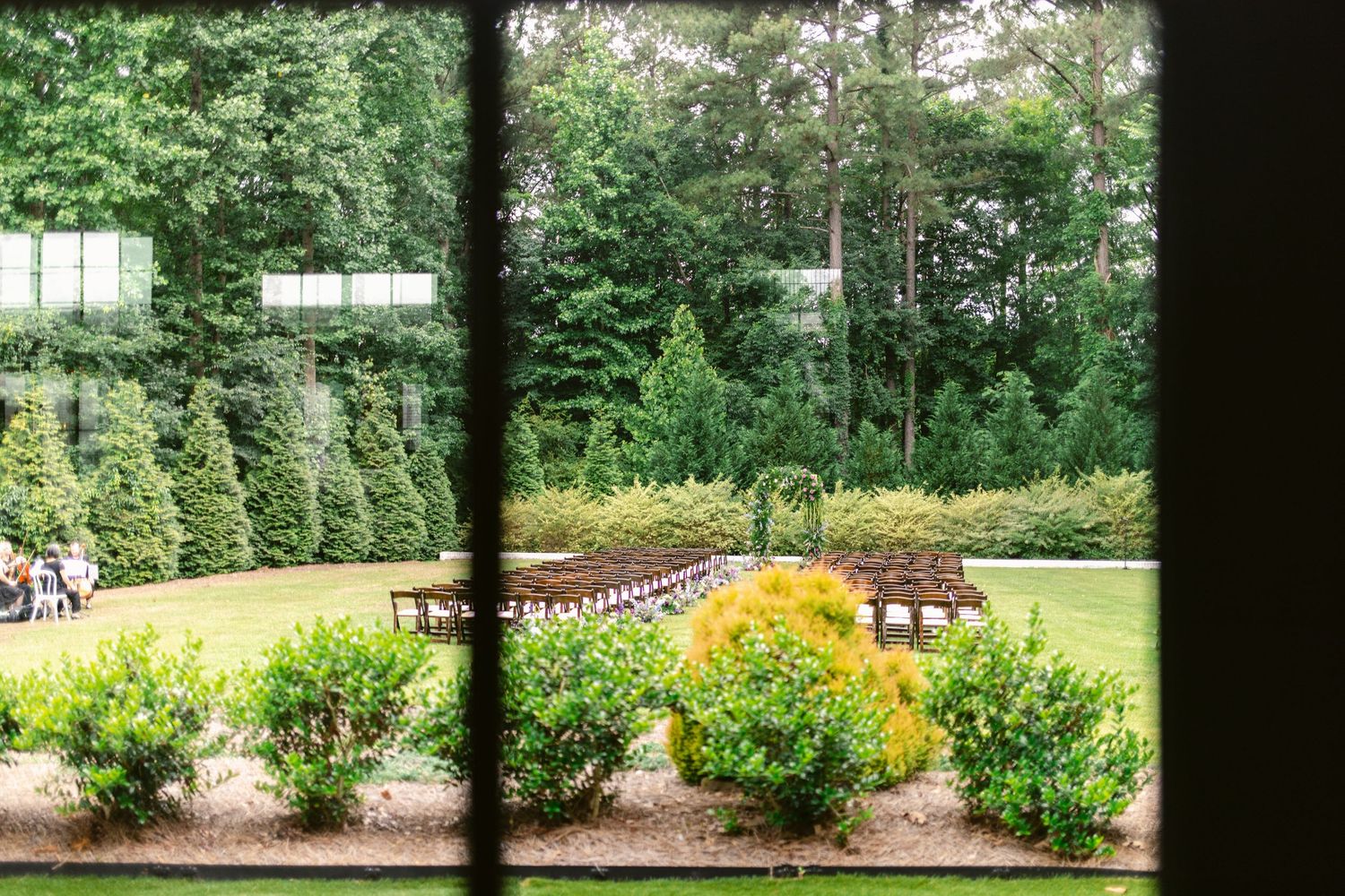 A lush garden landscape with colorful flowers and greenery stretches along a curved path bordered by trees.