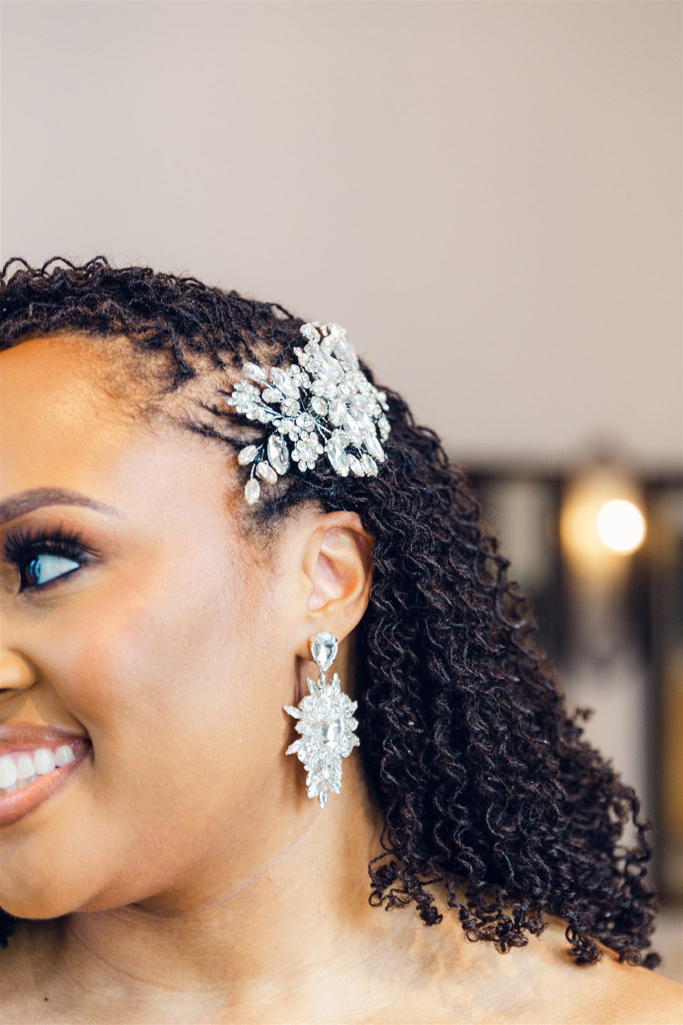 Beautiful bridal hair accessories featuring delicate crystal flowers adorning naturally curly dark hair.