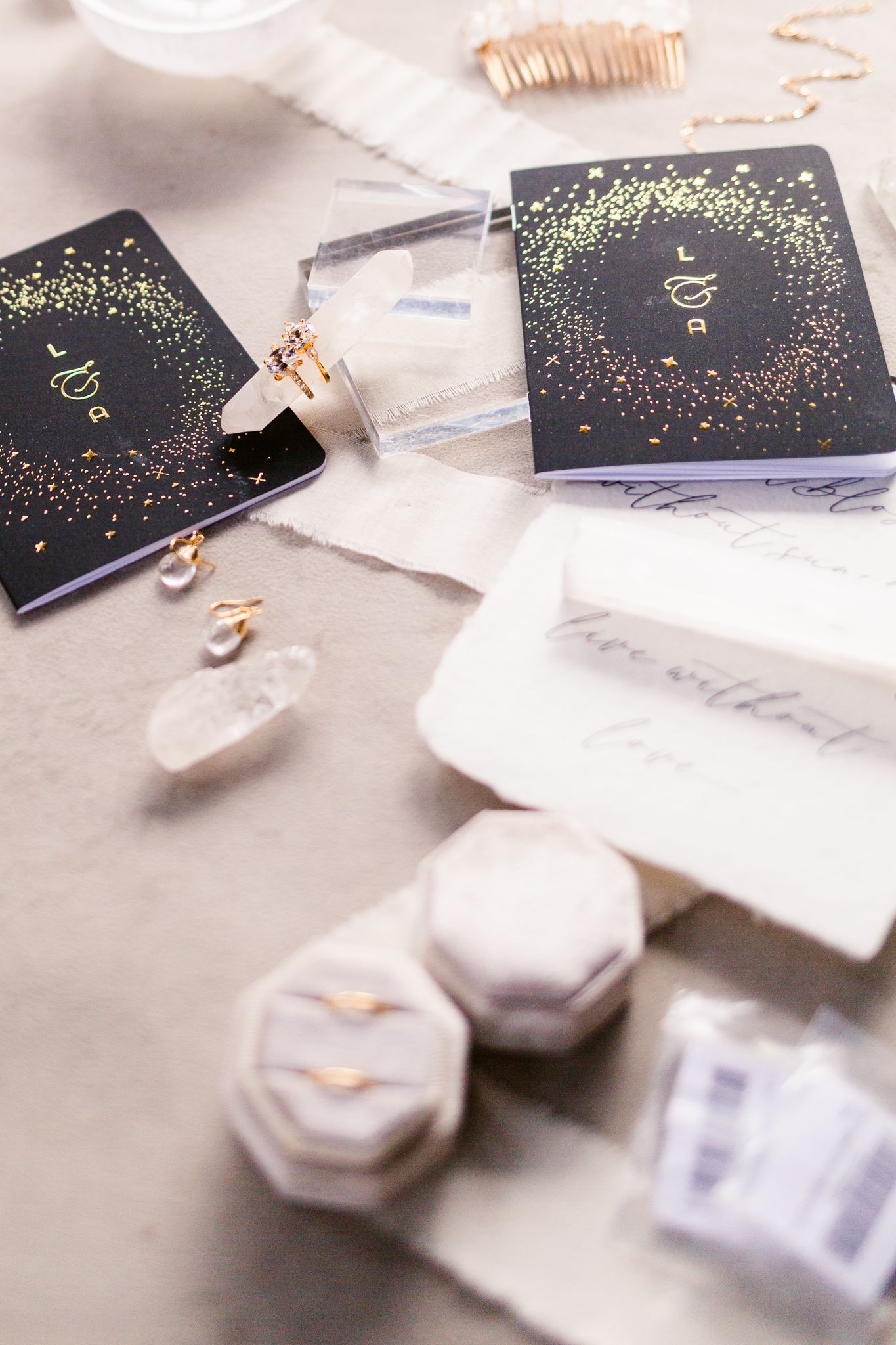 Elegant black gift boxes with sparkly gold confetti design displayed alongside marble hexagonal containers and ribbons.
