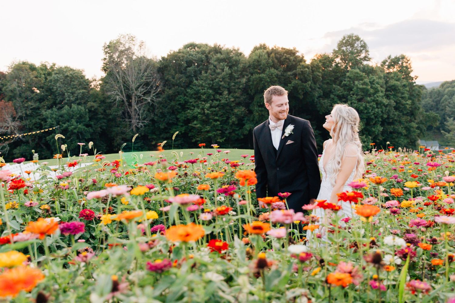 Newlyweds surrounded by vibrant wildflowers in a mountain garden setting.
