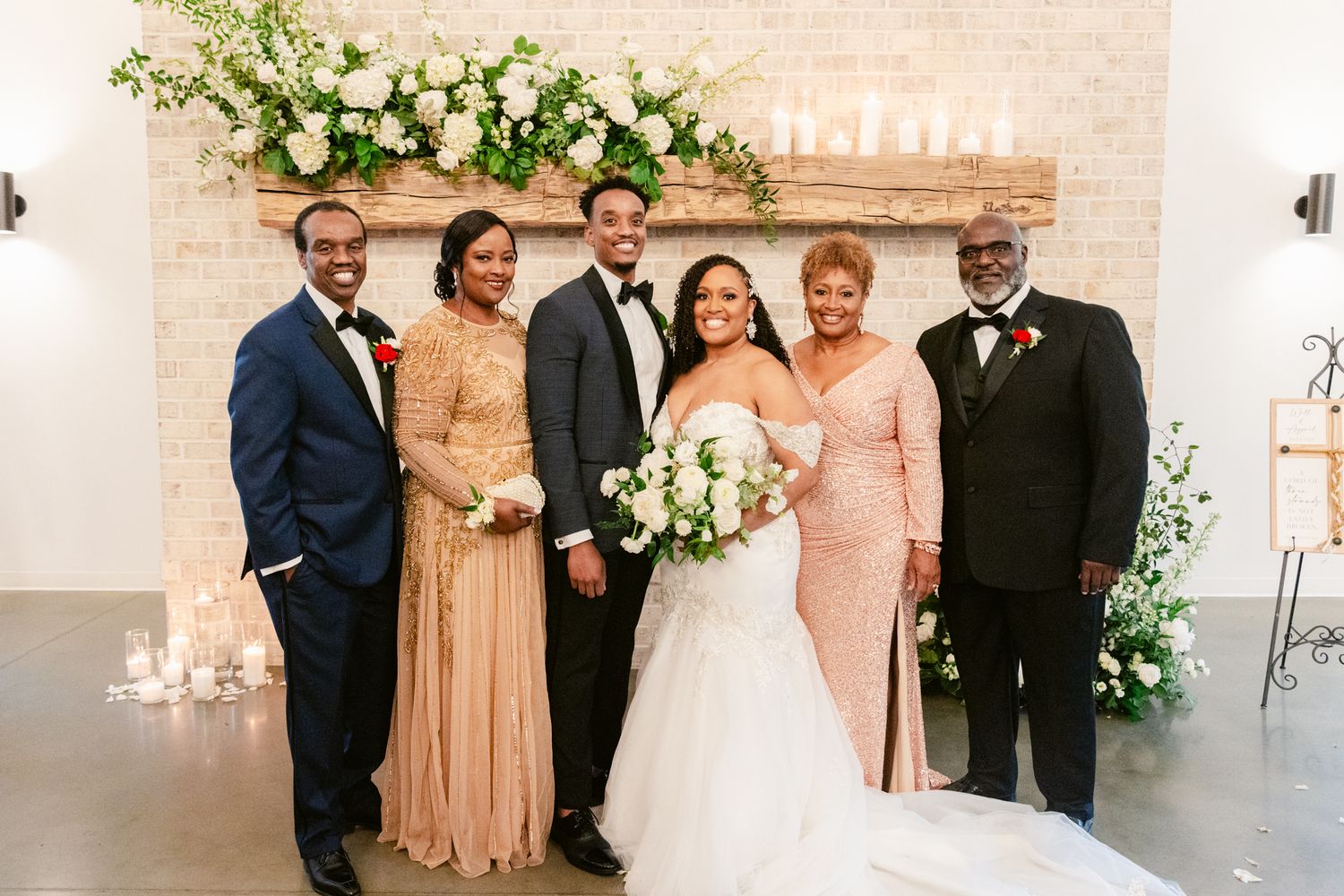 Small group poses together by elegant floral arrangement at wedding celebration.