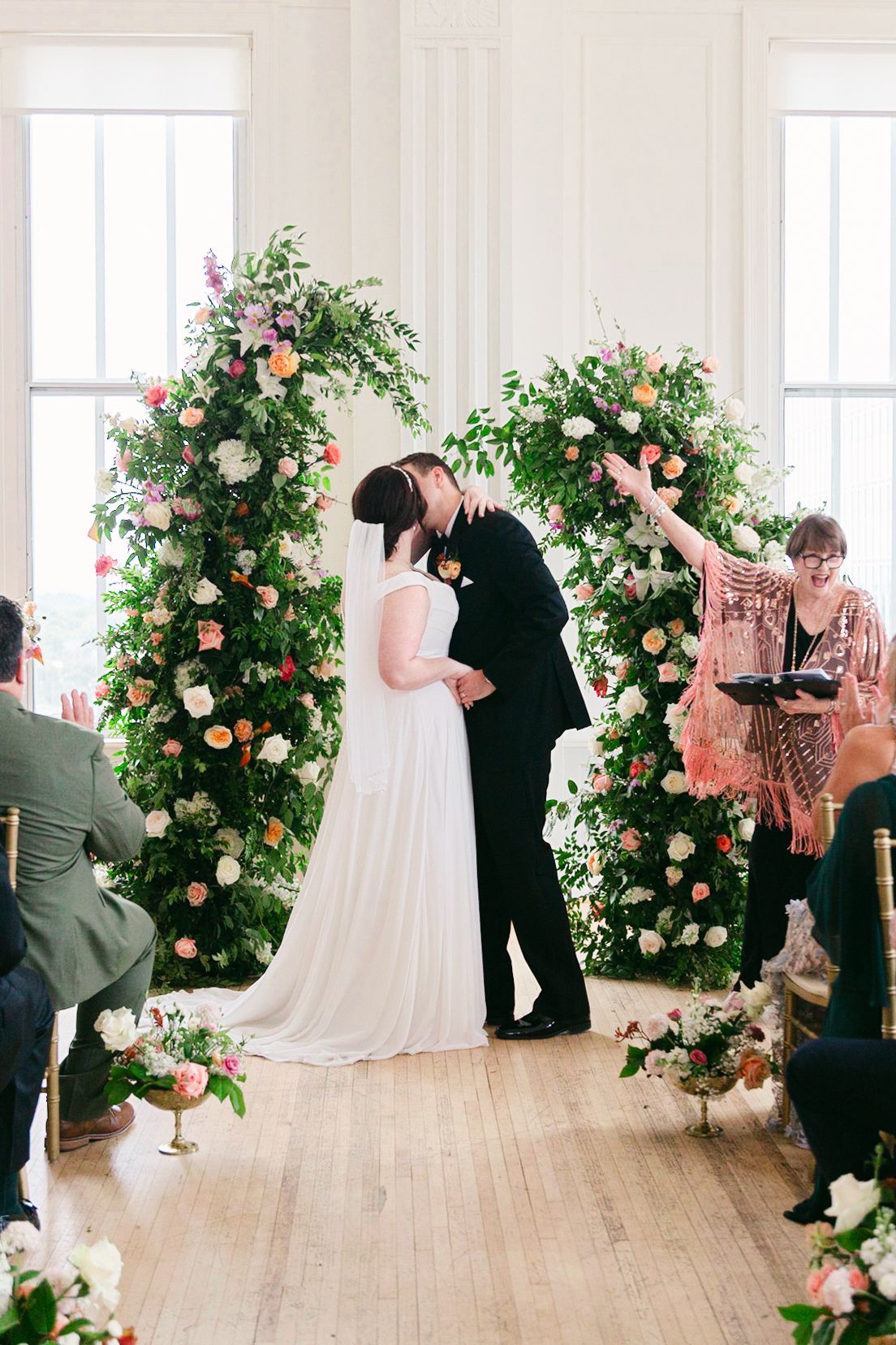 A sequence of four photos showing a couple dancing in an elegant room decorated with pink roses and greenery.
