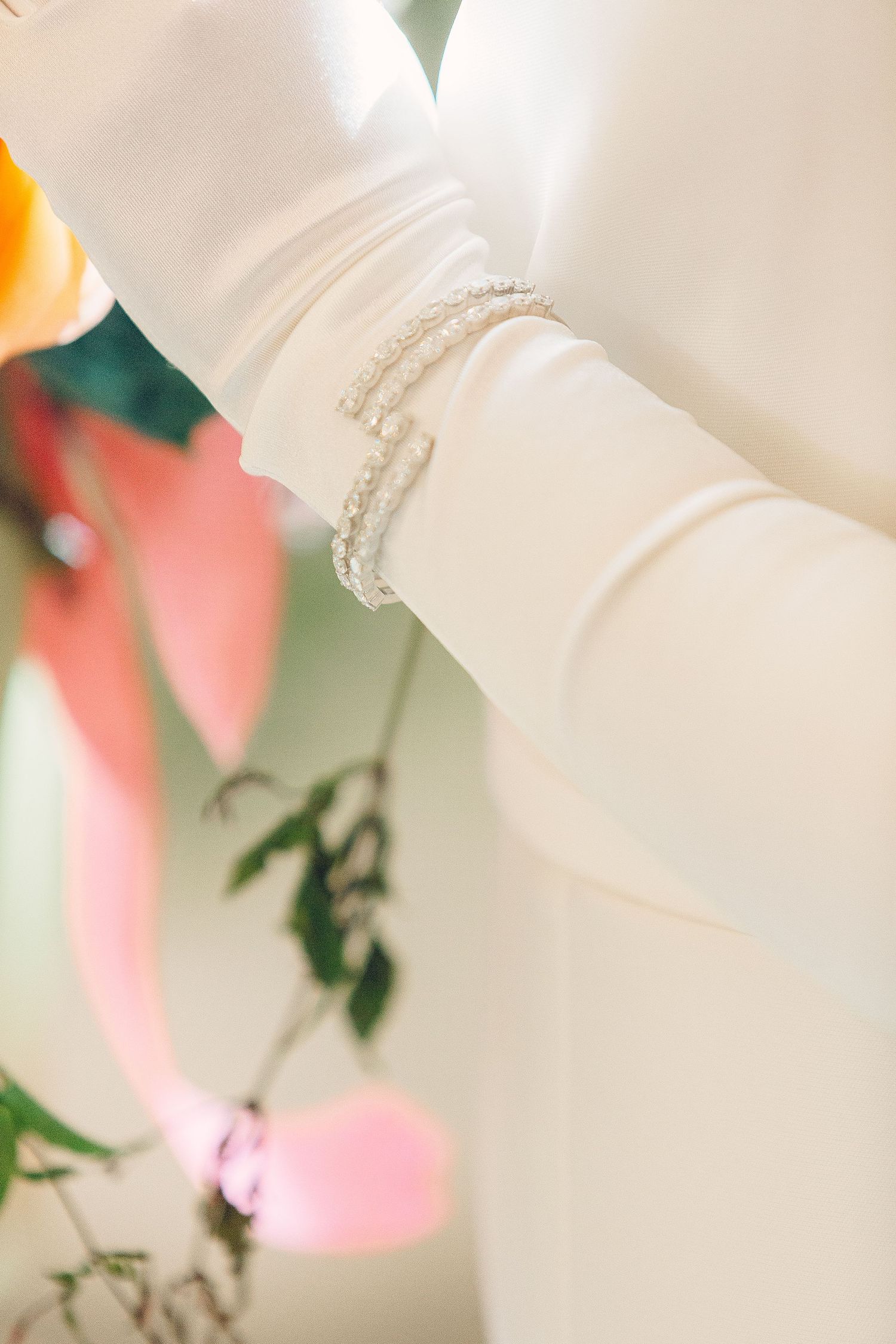 Close-up detail of delicate white wedding dress fabric with subtle texture.