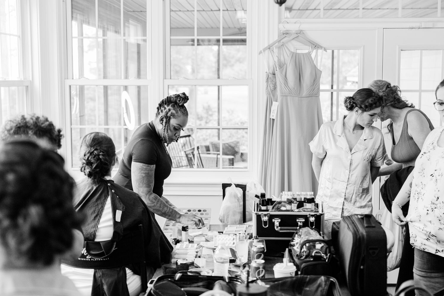 Vintage black and white photograph showing people working in a busy sewing factory with industrial machines.