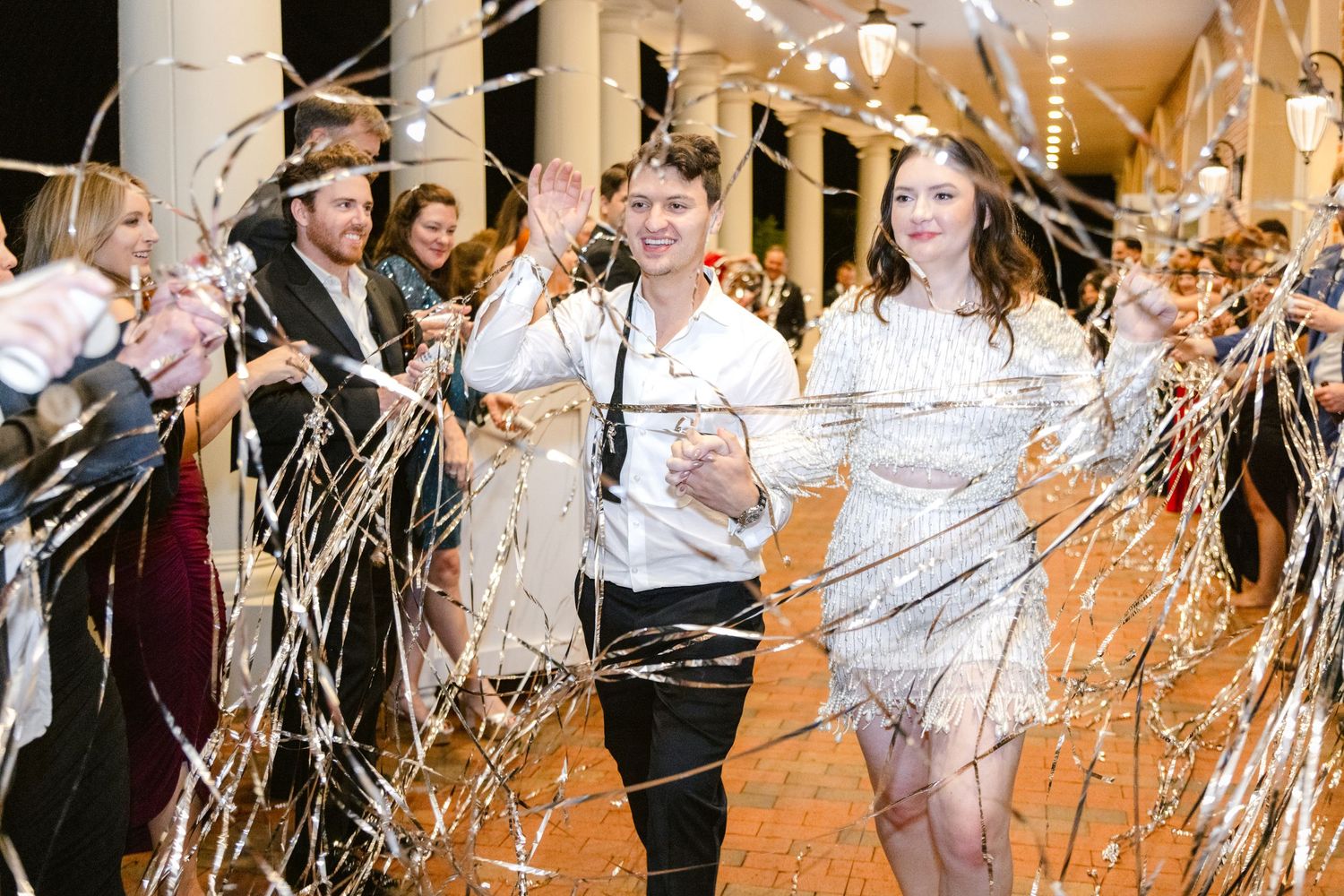 Wedding guests celebrate on the dance floor as sparklers create a magical atmosphere during a reception celebration.