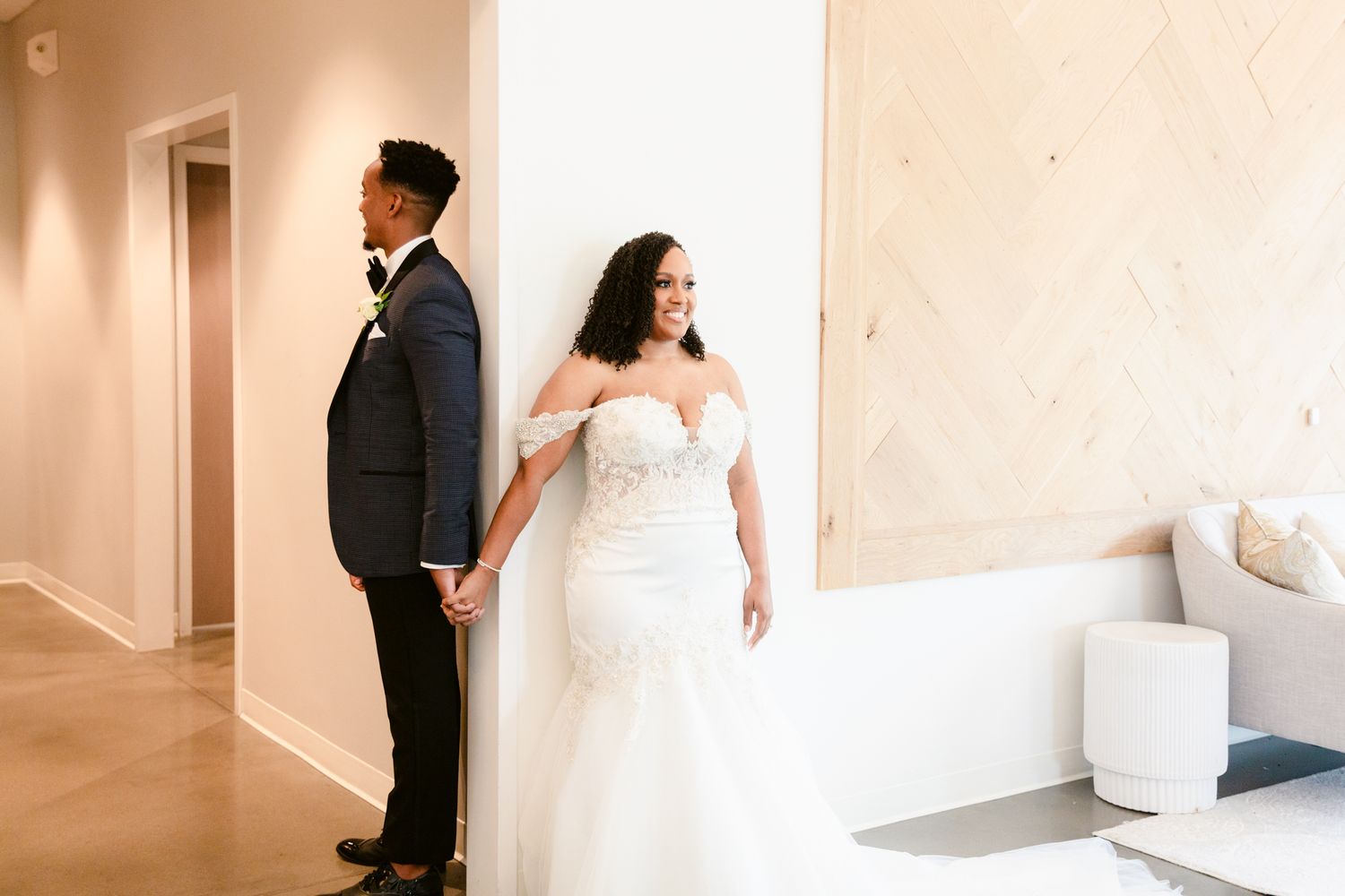 A bride and groom share an intimate moment in a minimalist white hallway during their wedding photoshoot.