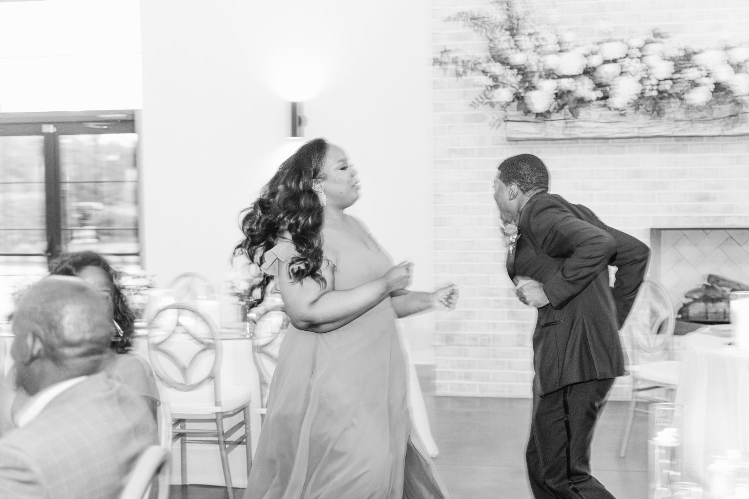 Wedding guests dancing and celebrating together on the dance floor at a joyous reception.