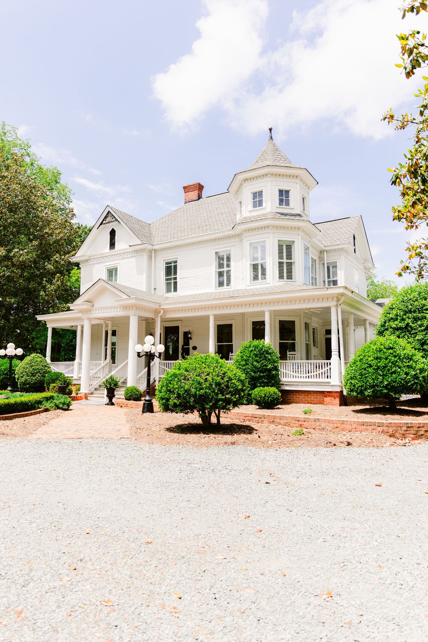 Classic white Southern mansion with wrap-around porch and cupola photographed from different angles.