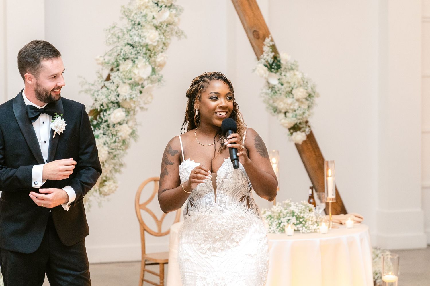 Wedding celebration with guests toasting and dancing in an elegant white venue.