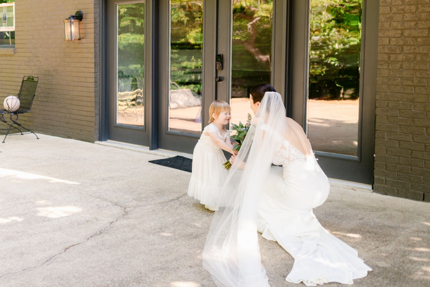 A couple sharing a joyful moment together outside a brick building with modern architectural details.
