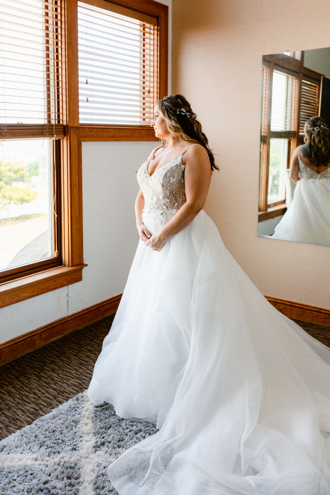 A flowing white wedding dress twirls and spins in a sunlit room with wooden-framed windows.