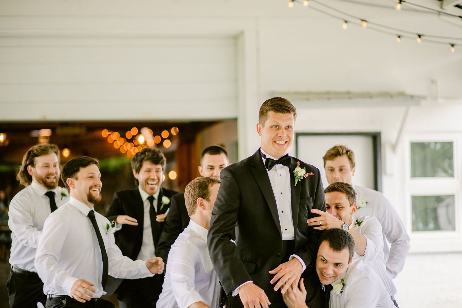 Wedding party having fun with playful group photo indoors.