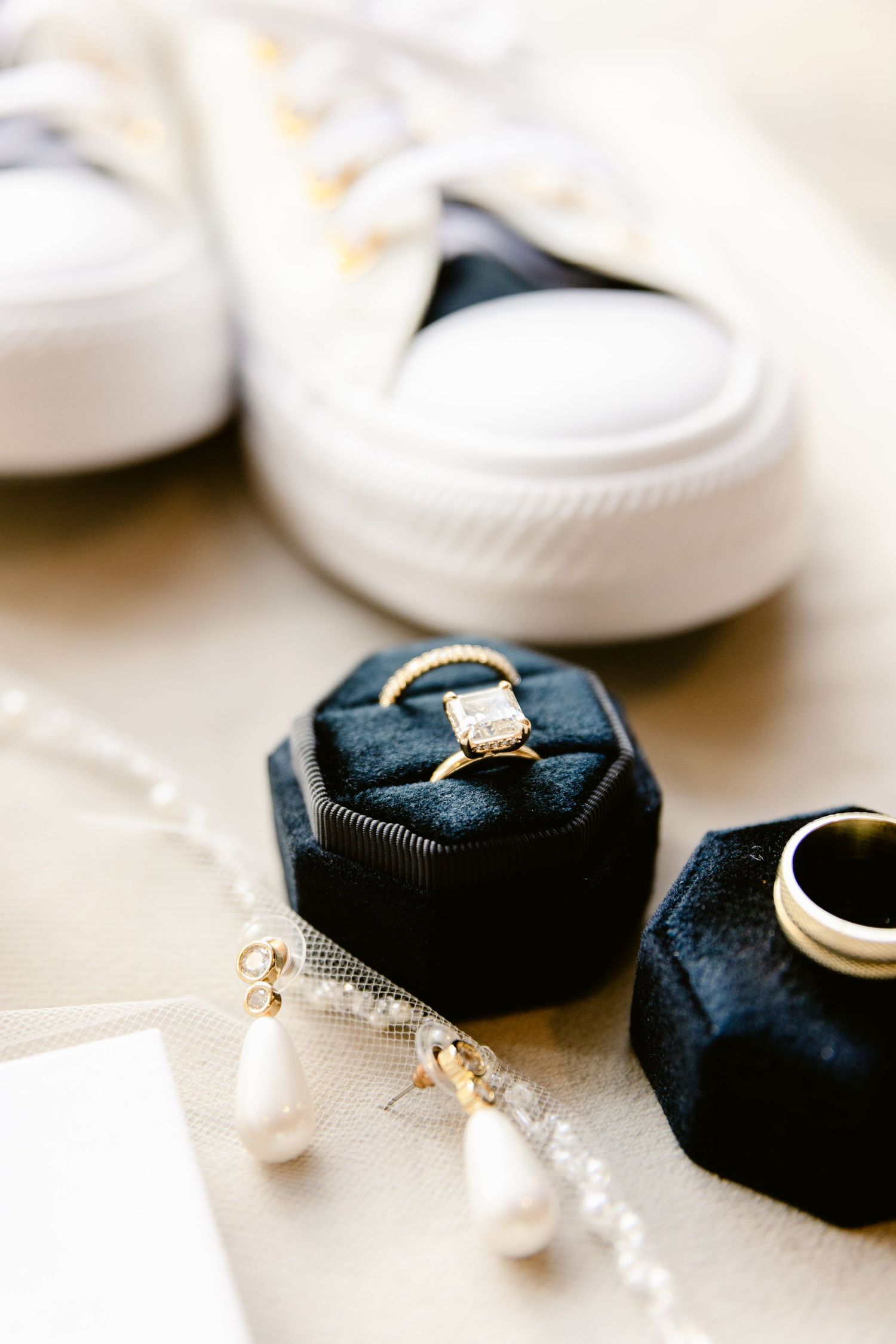 Close-up of an elegant diamond engagement ring nestled in a navy blue fabric holder.