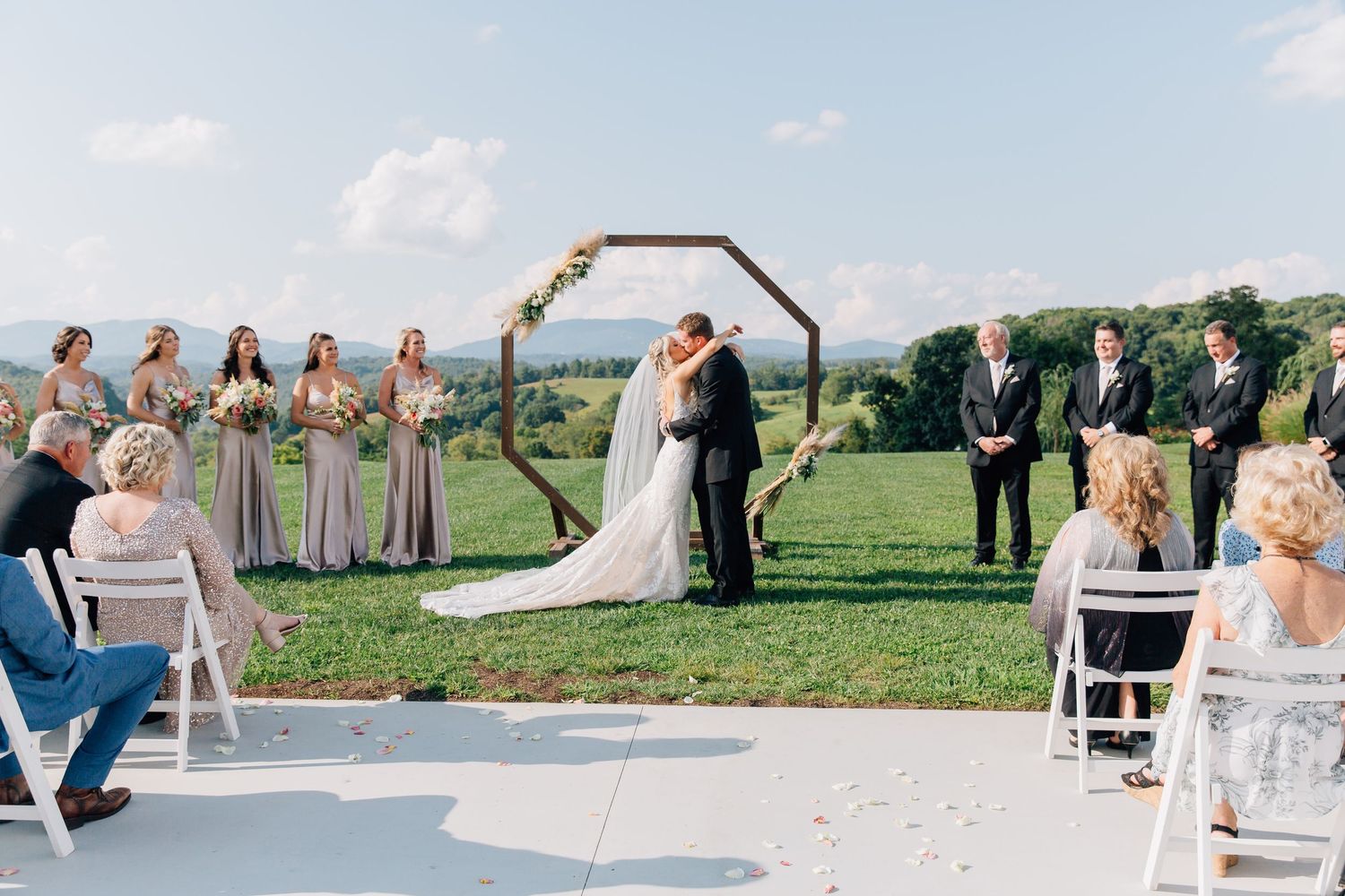 A panoramic collage of an outdoor wedding ceremony and reception in a scenic countryside setting.