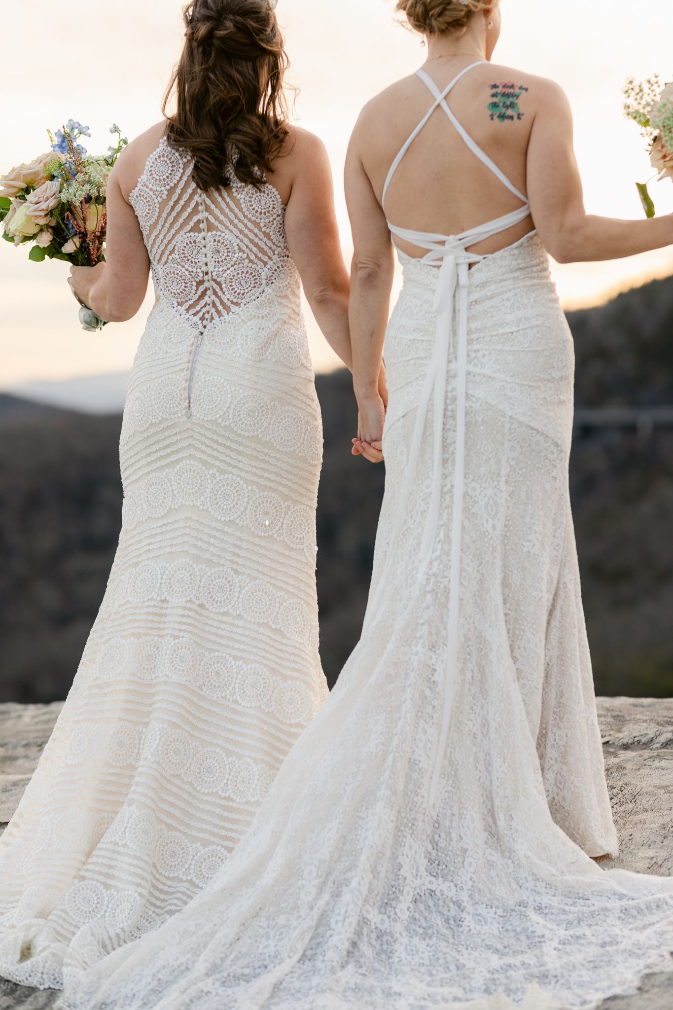 Two wedding dresses shown from behind featuring intricate lace patterns and criss-cross back straps.