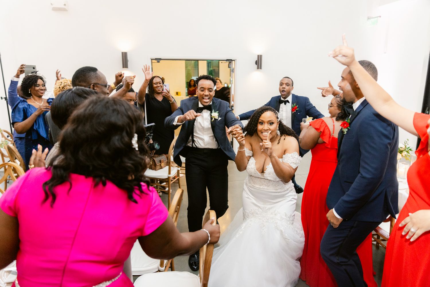 Wedding reception guests dancing and celebrating in formal attire.