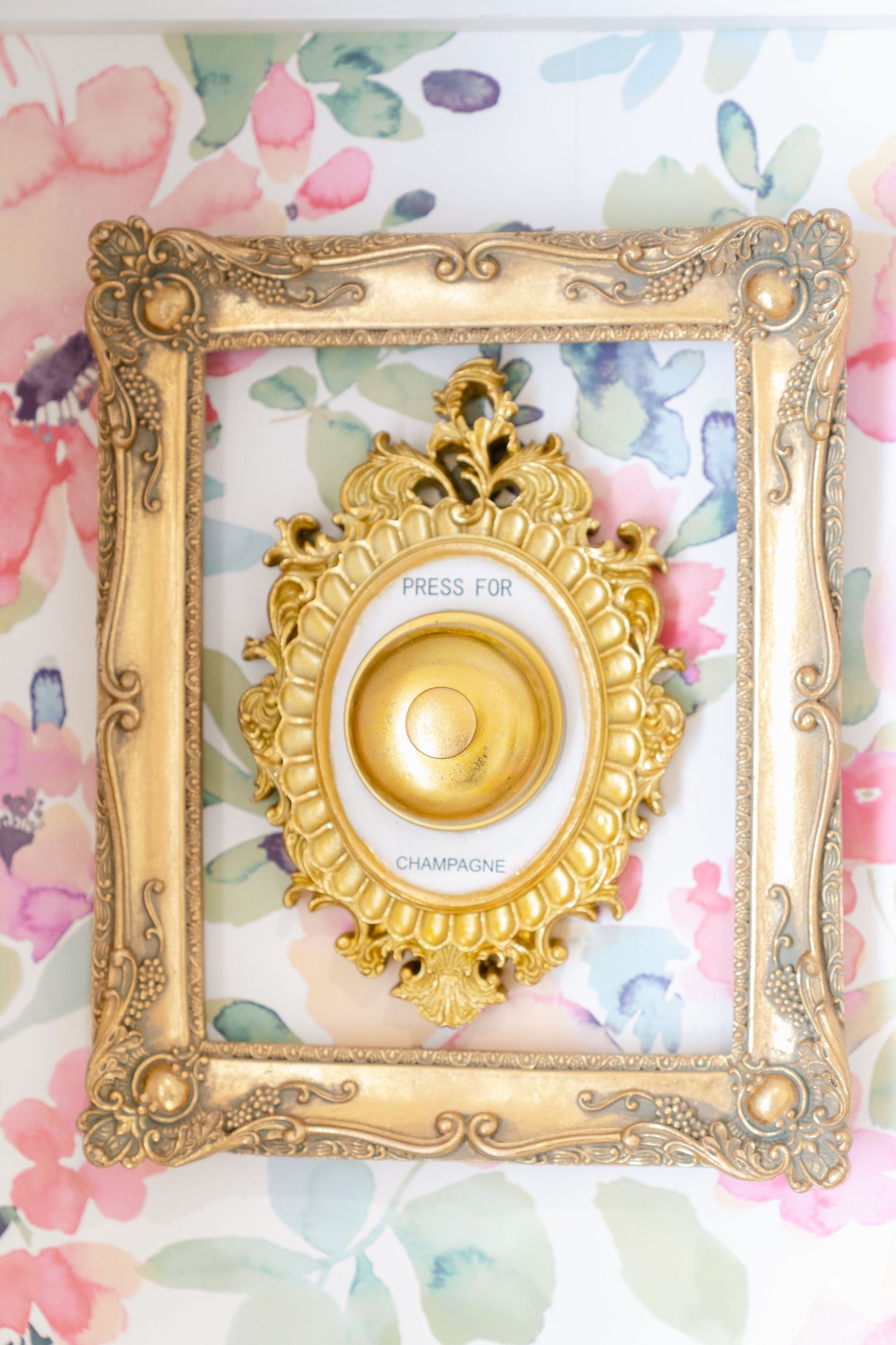 Ornate gold and cream vintage frame with decorative flourishes against floral watercolor background.