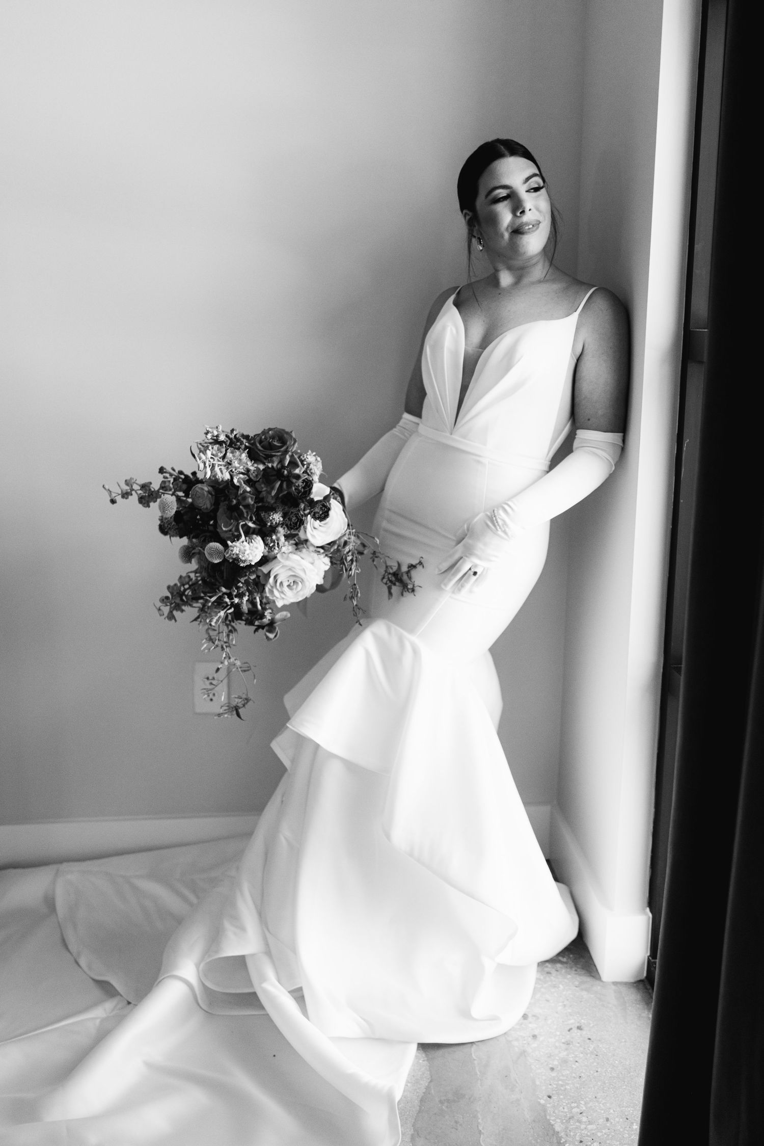 Black and white photos of someone in a flowing white dress twirling and posing with flowers.