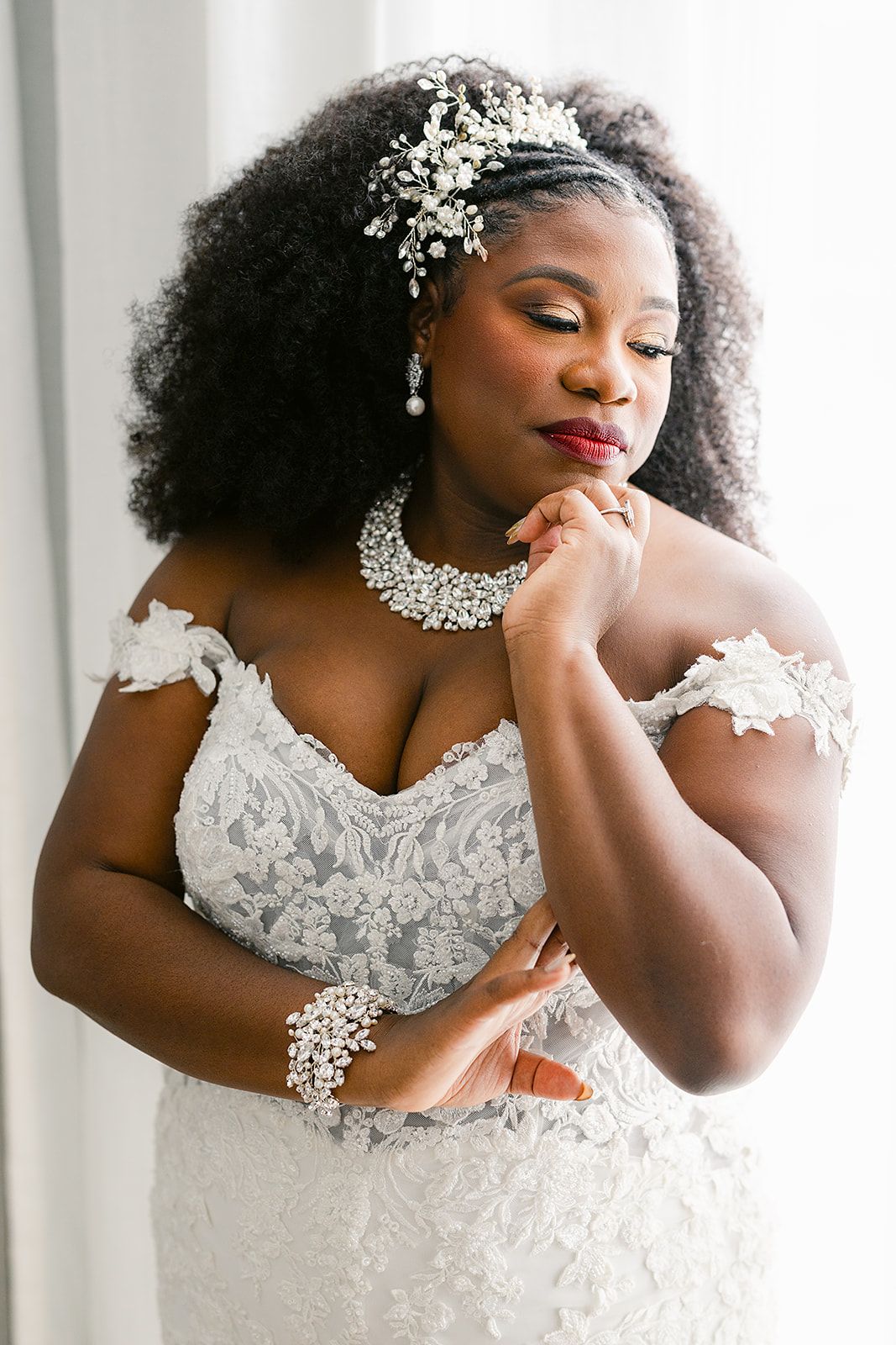 A beautiful bride in a white lace wedding dress with baby's breath hair accessories poses in four elegant portraits.