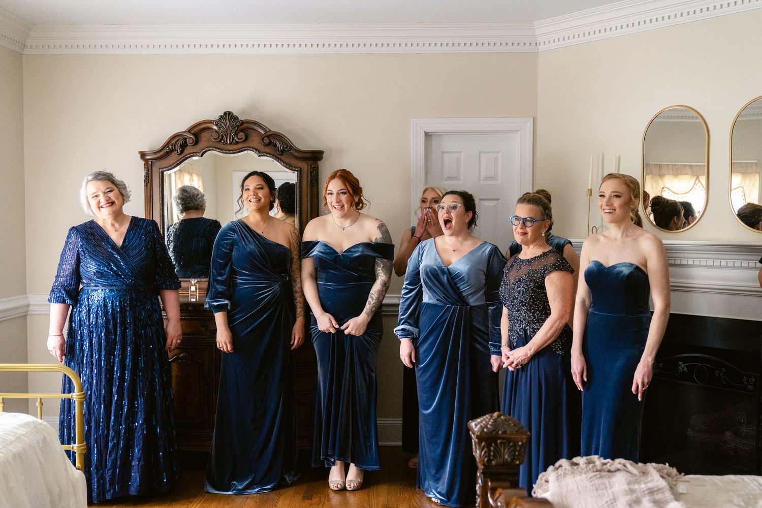Row of bridesmaids in navy blue dresses standing together during a wedding ceremony.