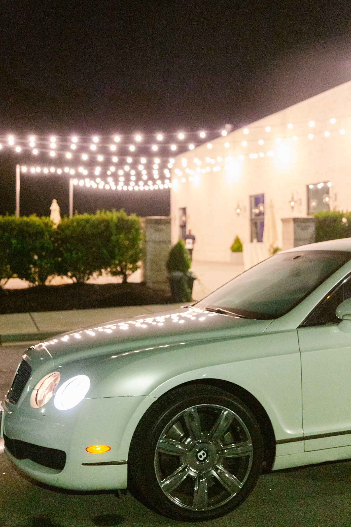 A white Mercedes-Benz coupe parked at night under decorative string lights with multiple angles shown.
