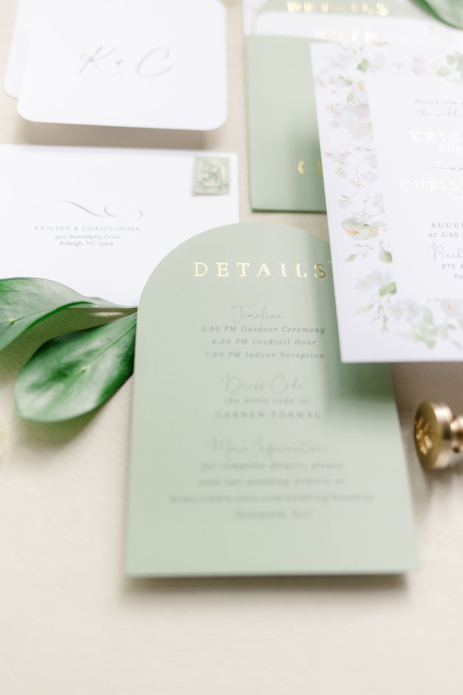 Wedding invitation suite in soft sage green with elegant calligraphy and botanical details on white background.