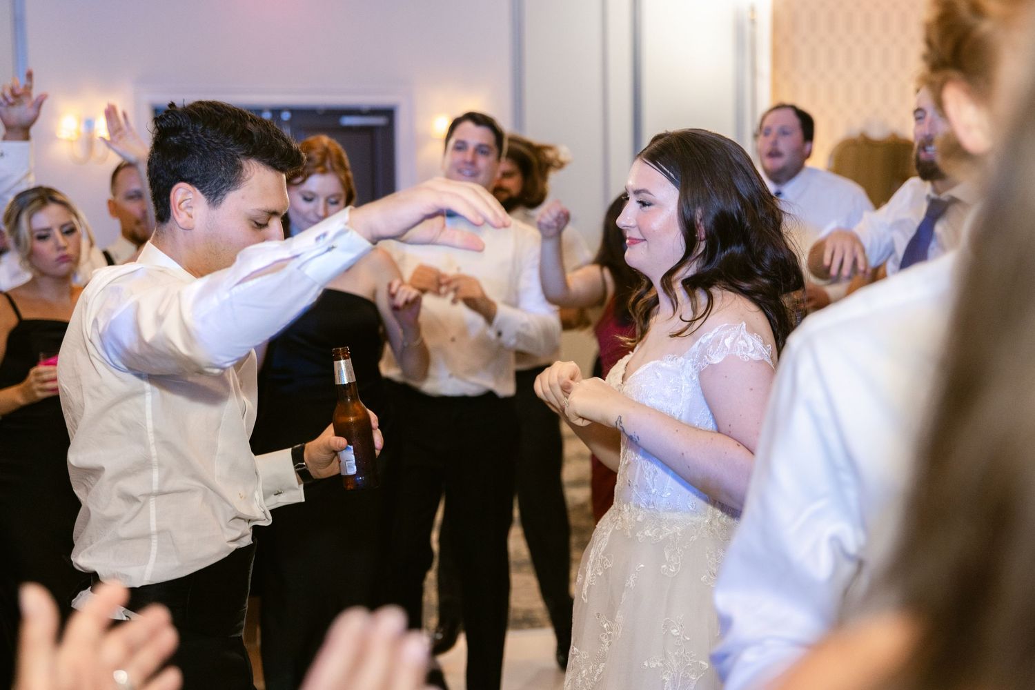 Wedding guests dancing and celebrating together on the dance floor at a reception.
