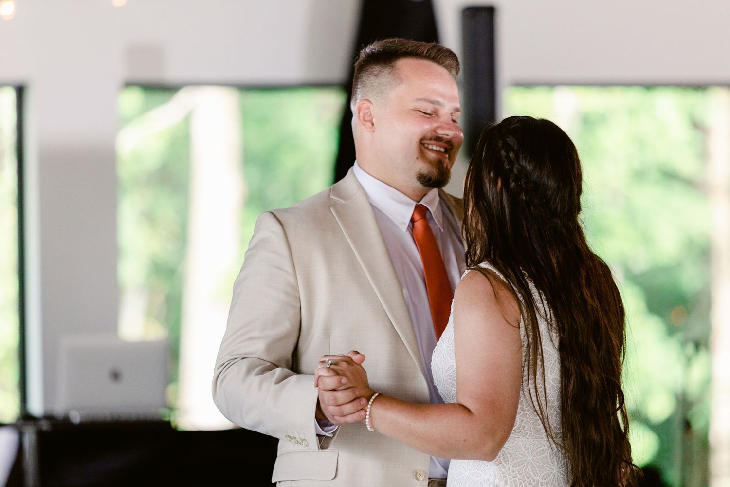 Wedding couple shares a tender dance moment together in an elegantly decorated reception venue.