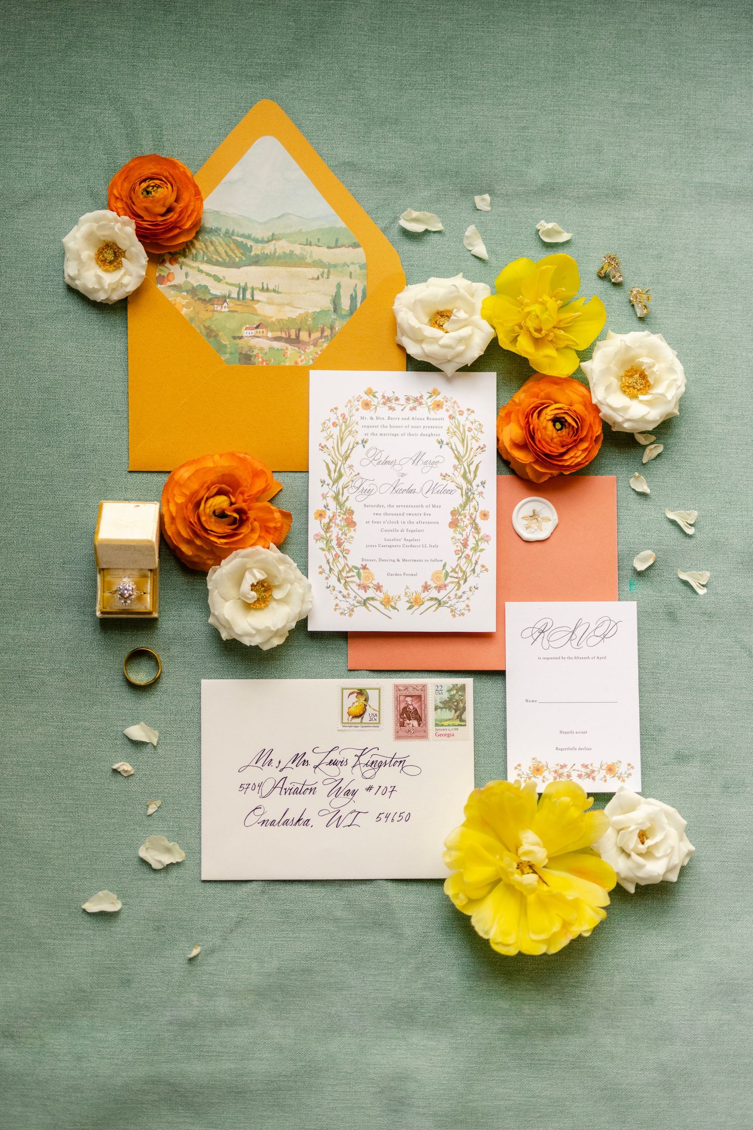 Wedding invitation suite with orange and yellow flowers arranged on sage green background with elegant calligraphy.
