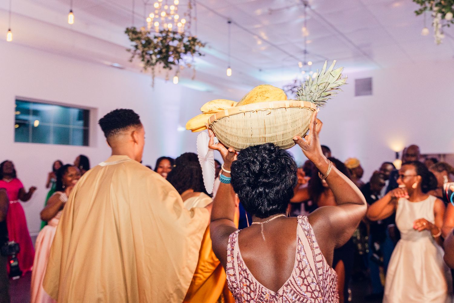 Wedding reception venue with chandelier and decorative foliage.