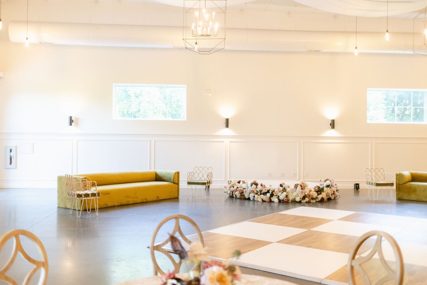 Bright and spacious dance studio with hardwood floors, mirrored walls, and natural light streaming through large windows.