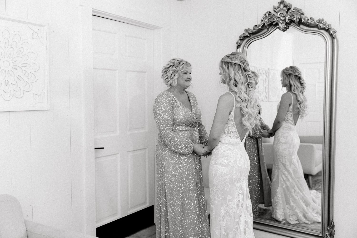 A collage of black and white photos showing a bride getting ready in a dressing room with mirrors and gowns.