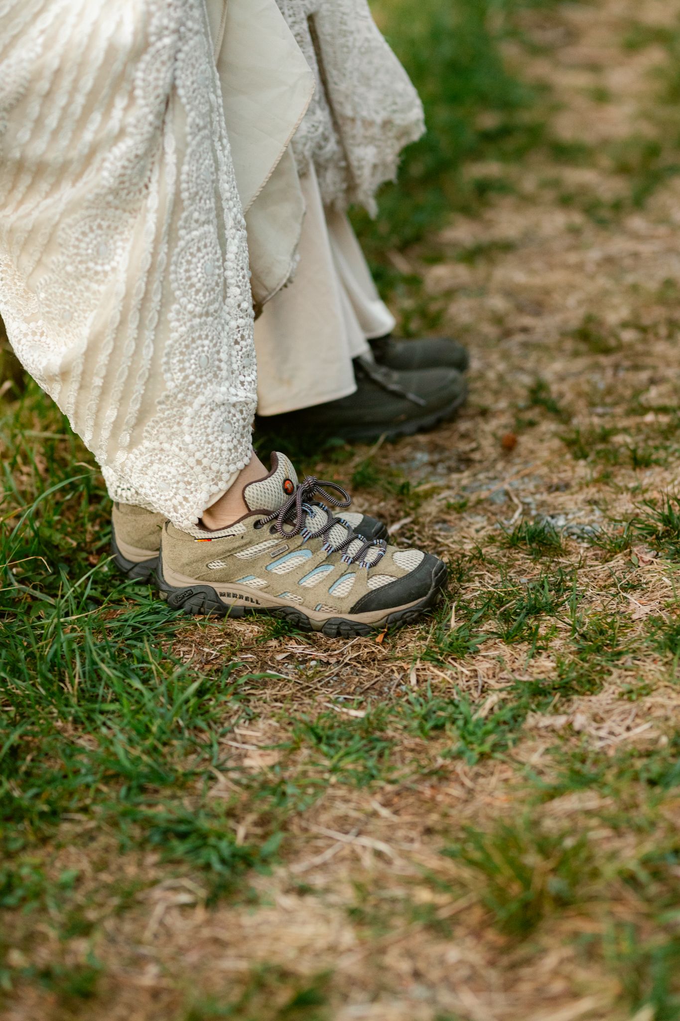 Close-up of hiking boots and dress hem showing practical footwear choice for outdoor celebration.
