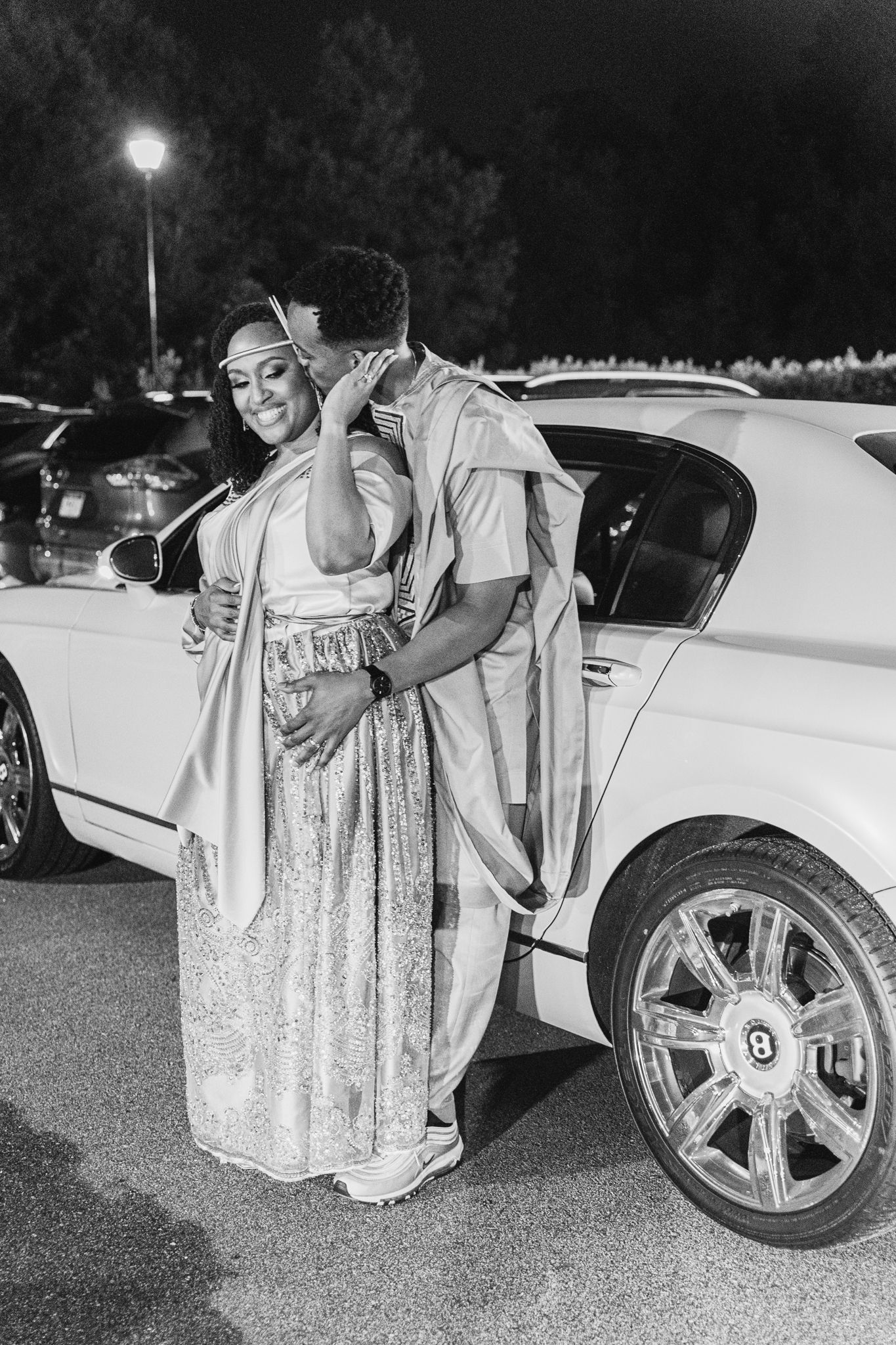A series of black and white photos showing someone in a sparkly dress examining a luxury car's wheel and tire.