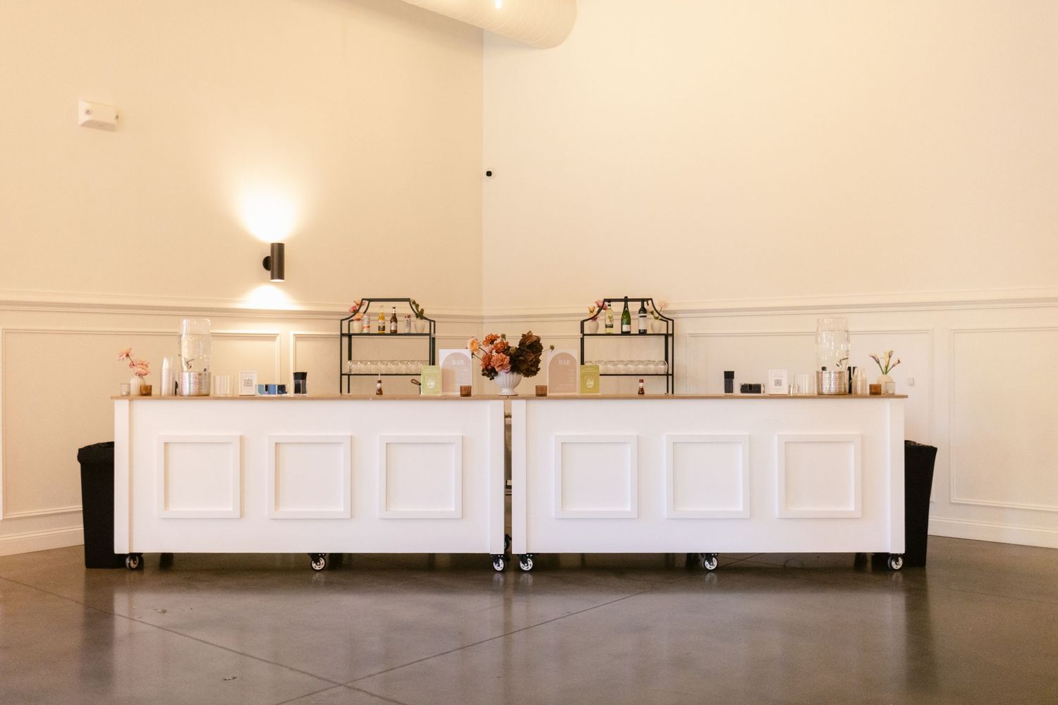 White wainscoting panels line the walls of an empty room with hardwood flooring and decorative arched moldings.
