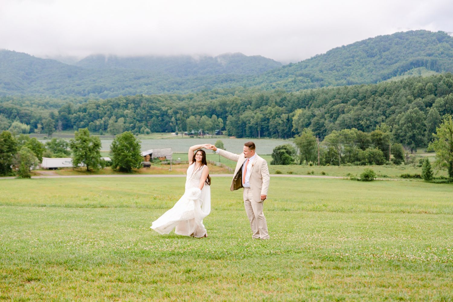 Wedding party walking through a scenic mountain meadow on a summer day.