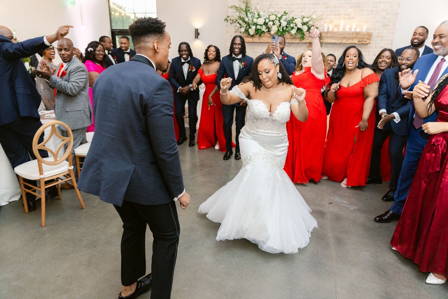 Wedding guests dance and celebrate on a spacious dance floor at an elegant reception venue.