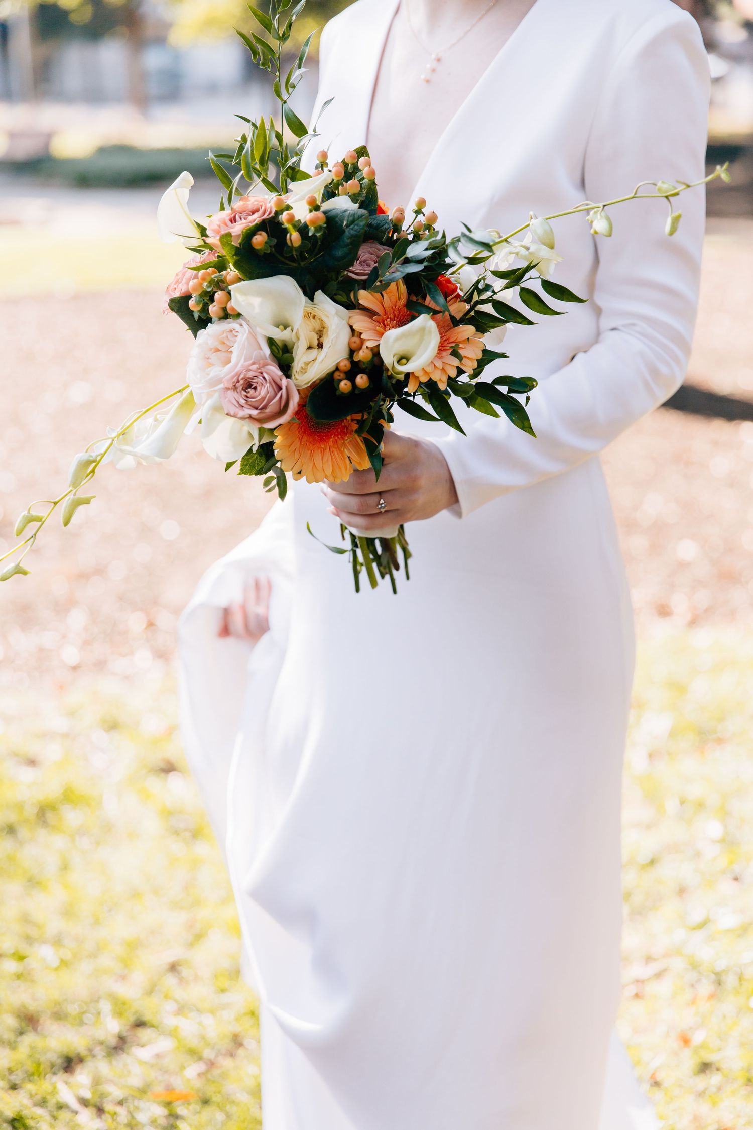 A white maternity dress is showcased in multiple photos with a beautiful floral bouquet of roses and greenery.