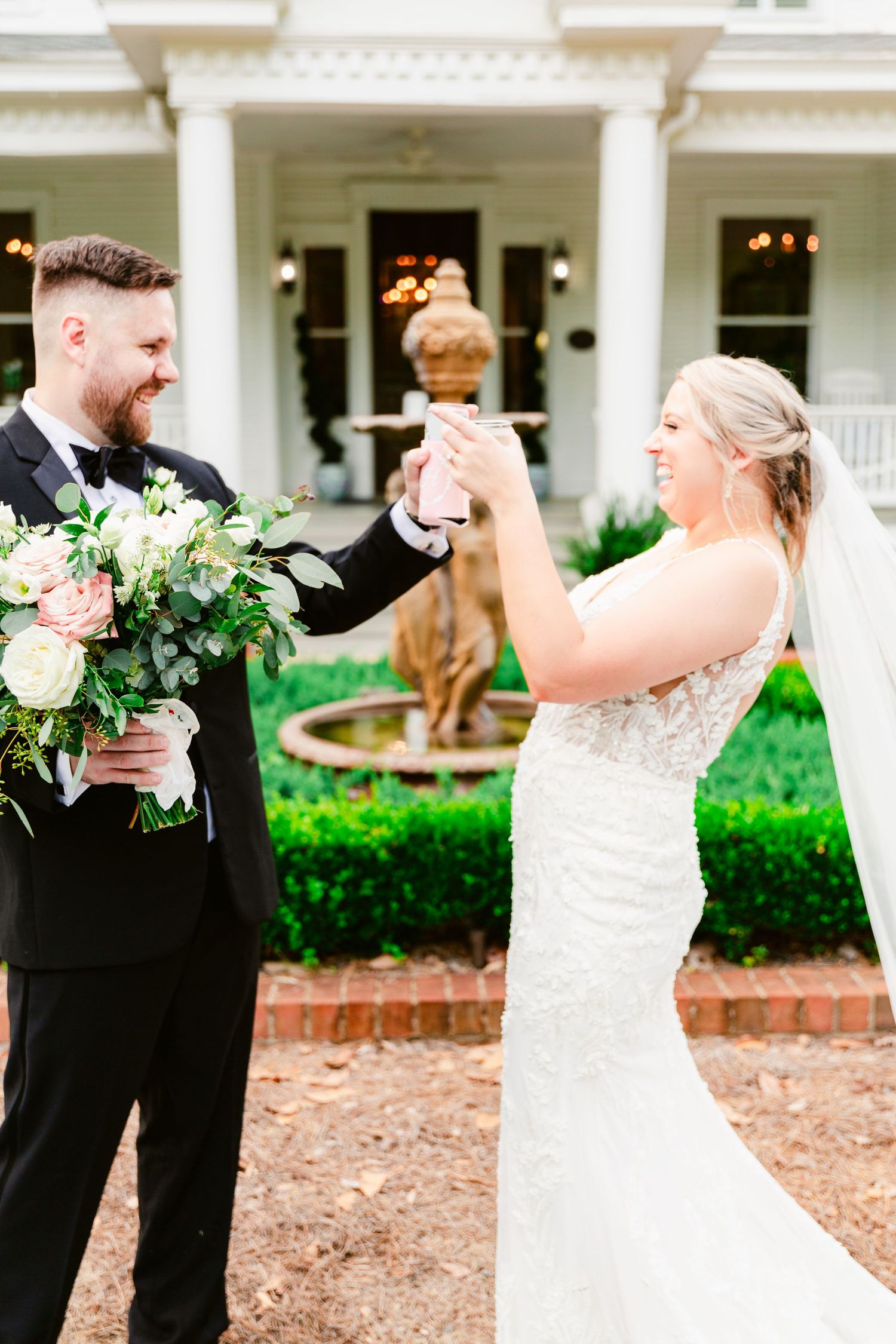 A romantic first look moment between newlyweds on their wedding day outside a white columned building.