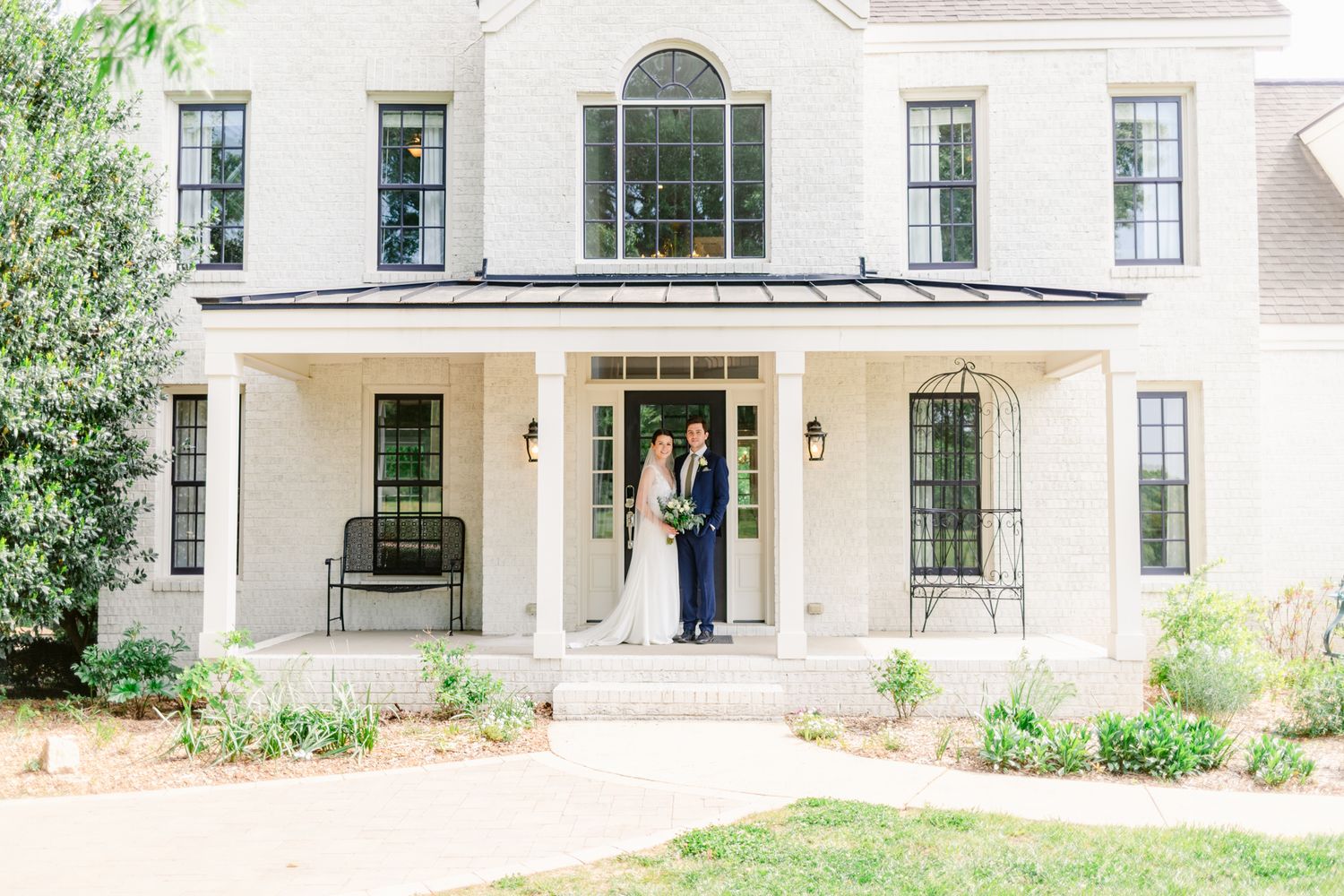 Exterior view of a white residential home with arched windows and traditional architectural details.